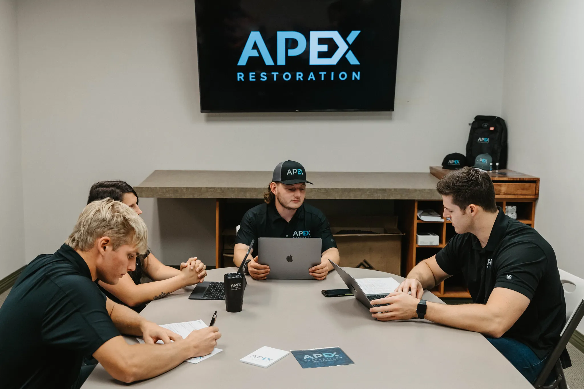 Apex Restoration team member standing beside company service truck in Boise